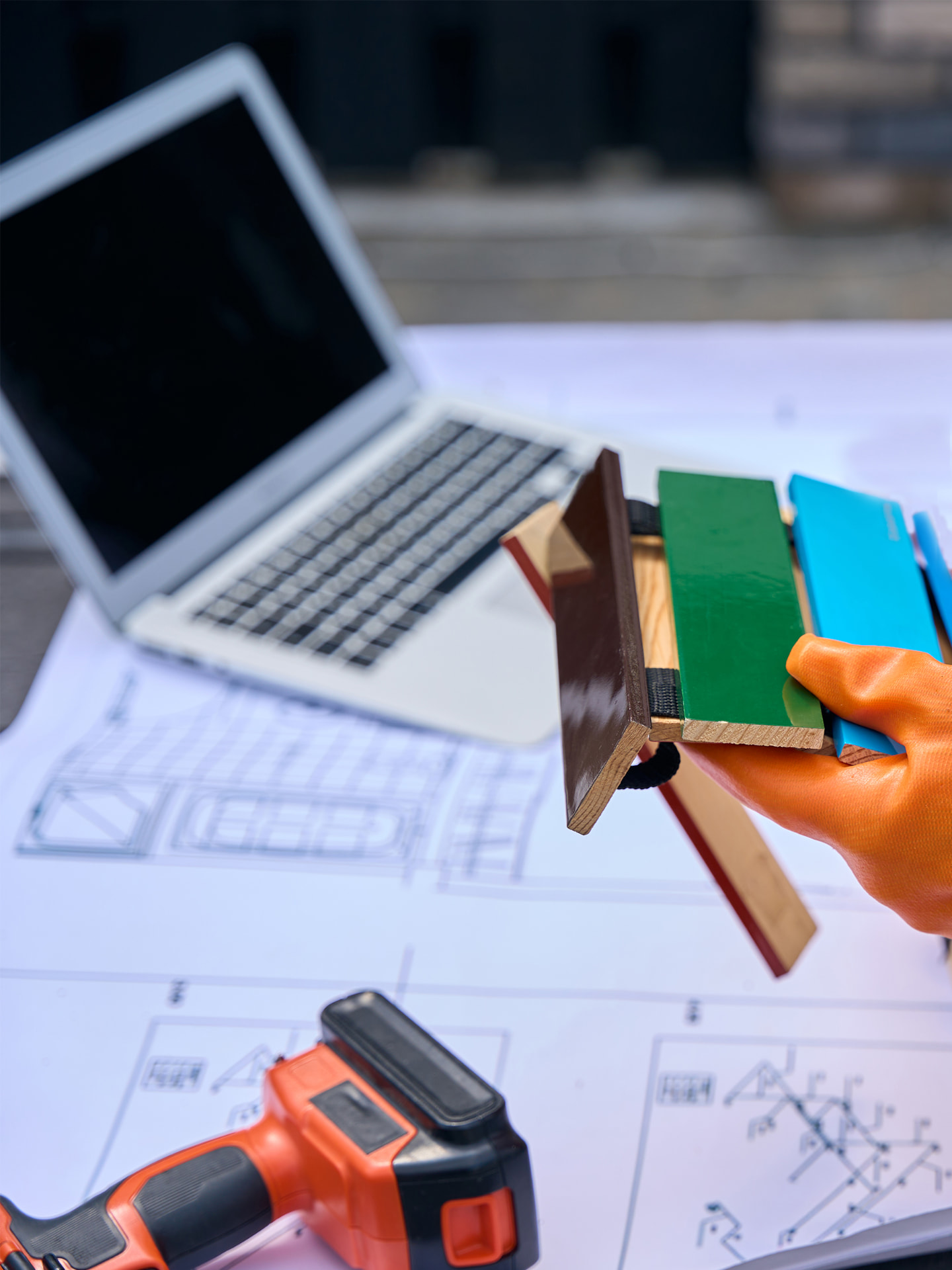 Fabricator reviewing coated samples with project blueprints